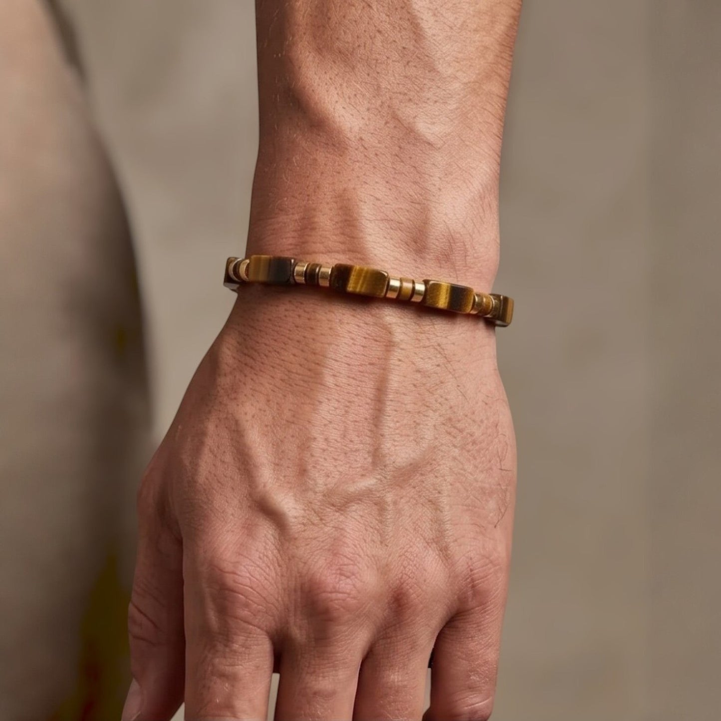 Naya-Linn Jewelry minimalist men's bracelet with rectangular tiger eye beads and gold-plated accents on a wrist.
