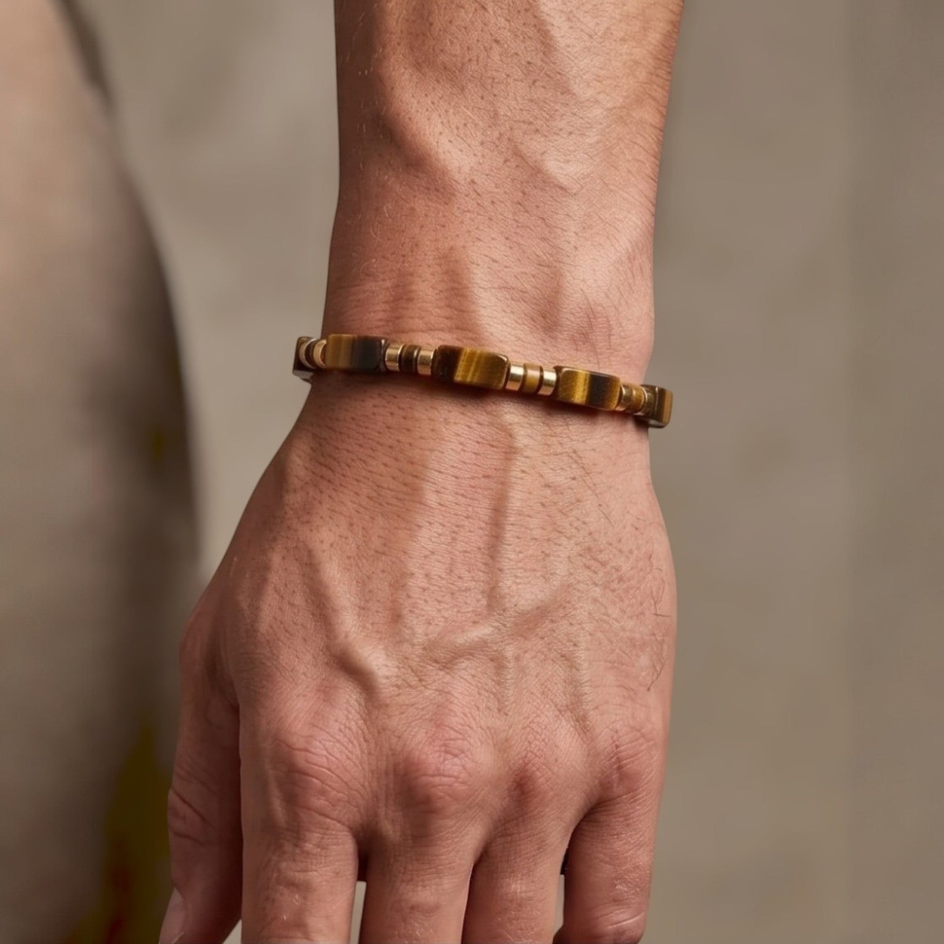 Naya-Linn Jewelry minimalist men's bracelet with rectangular tiger eye beads and gold-plated accents on a wrist.